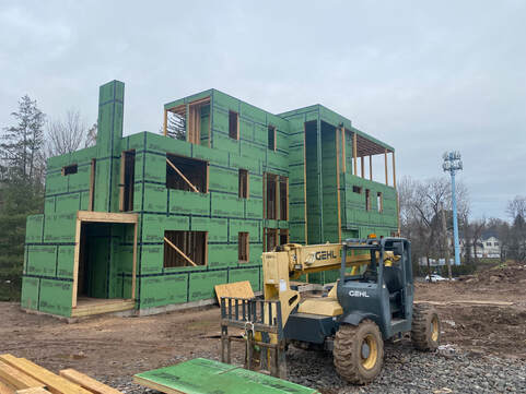 Front view of construction site with new home framing by EDW Builders